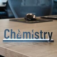 Chemistry-themed office nameplate on a desk